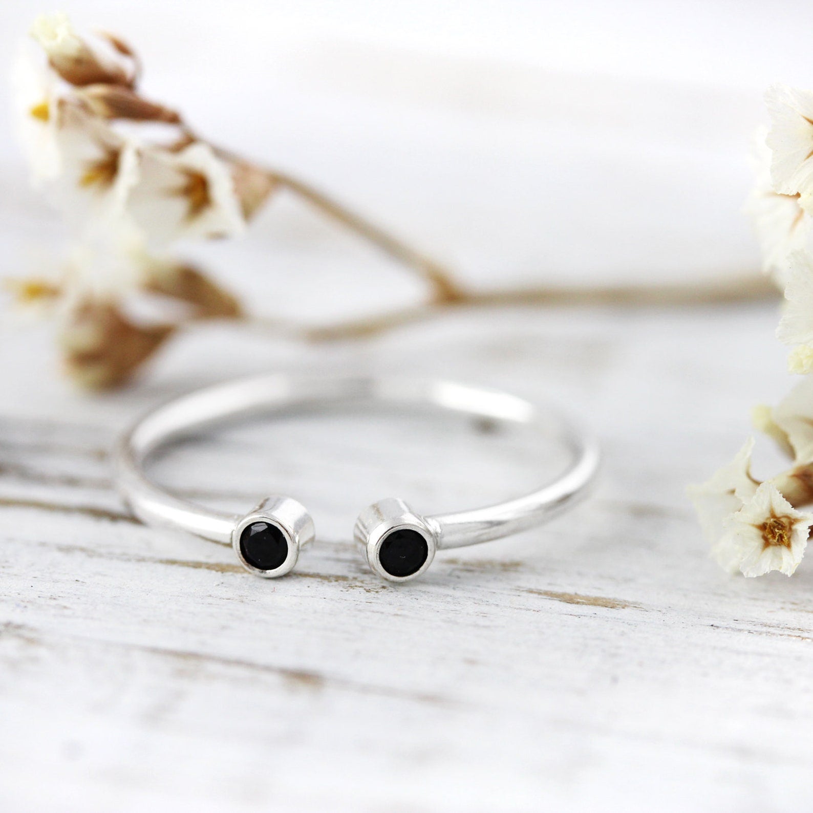 Open ring with two black stones